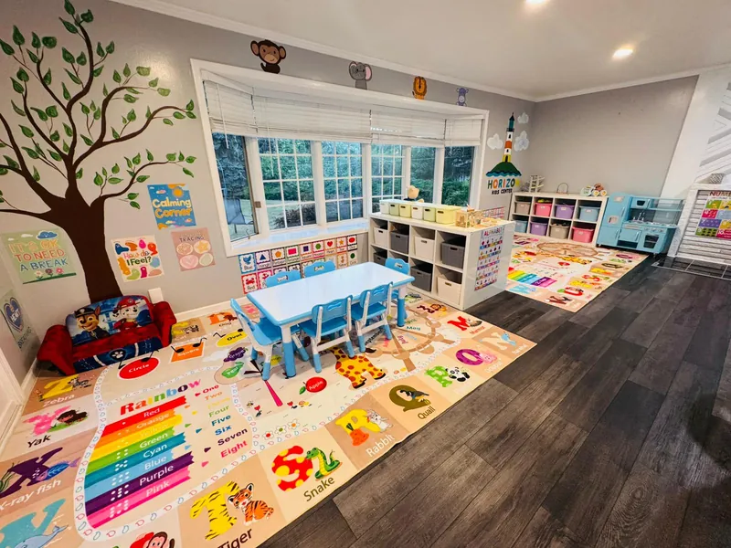 Learning center with tree mural, educational charts, and organized storage systems