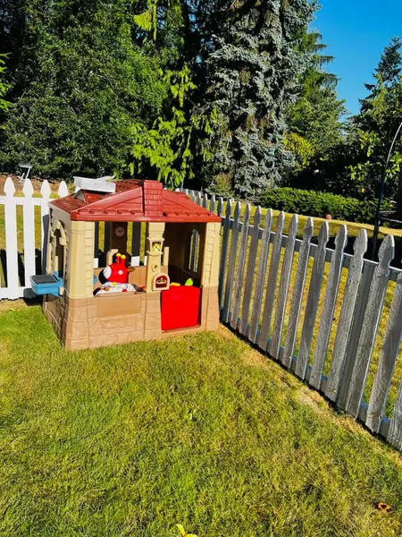 Outdoor playhouse in fenced yard